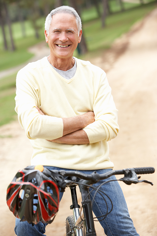 photo of a senior man riding bicycle in park