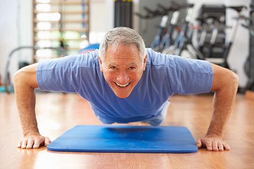 photo of senior man doing push ups in gym